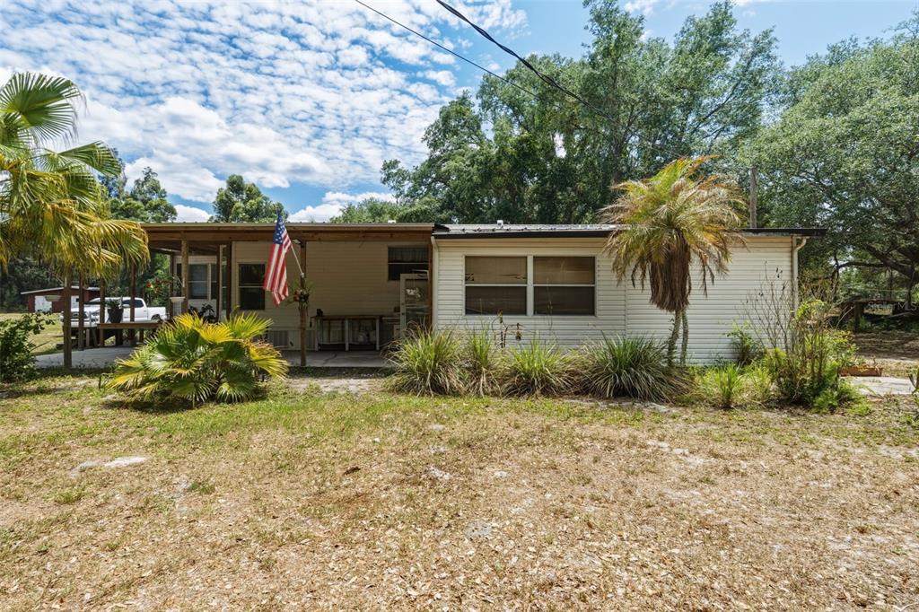The exterior of a single-story mobile home features a covered porch and a front yard — 4981 NW HICKORY STREET, ARCADIA, FL