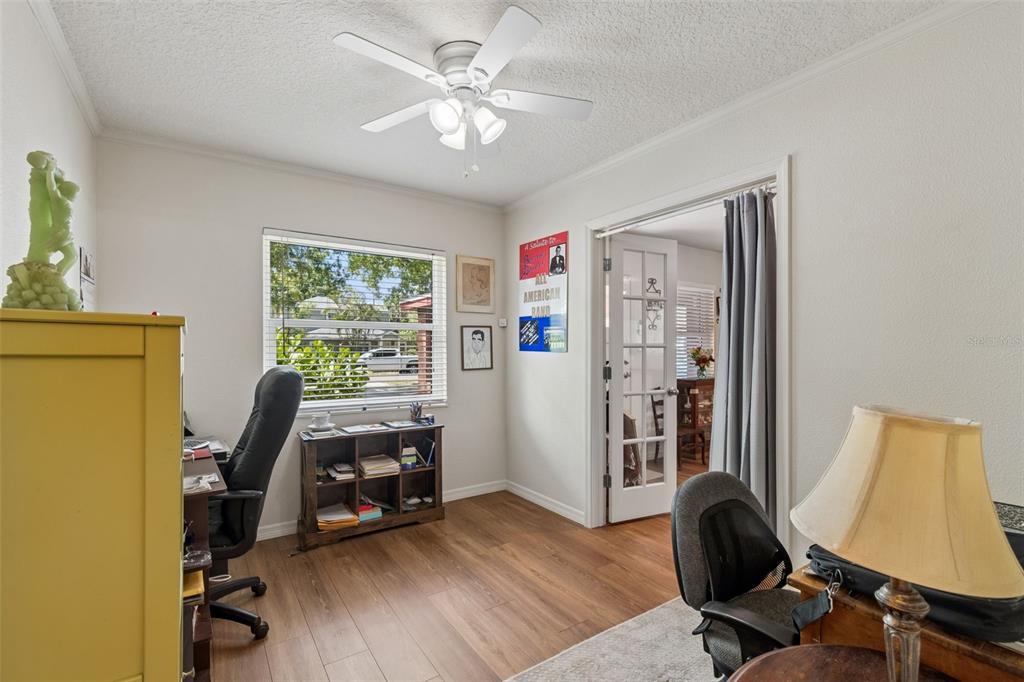 A home office features wood-look flooring, a ceiling fan, a window, and a French door — 4727 W ANITA BOULEVARD, TAMPA, FL