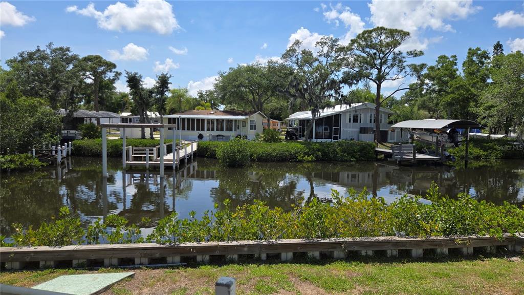 A canal view shows several waterfront homes with private docks and boat slips — 3333 26TH AVENUE E UNIT 1291, BRADENTON, FL
