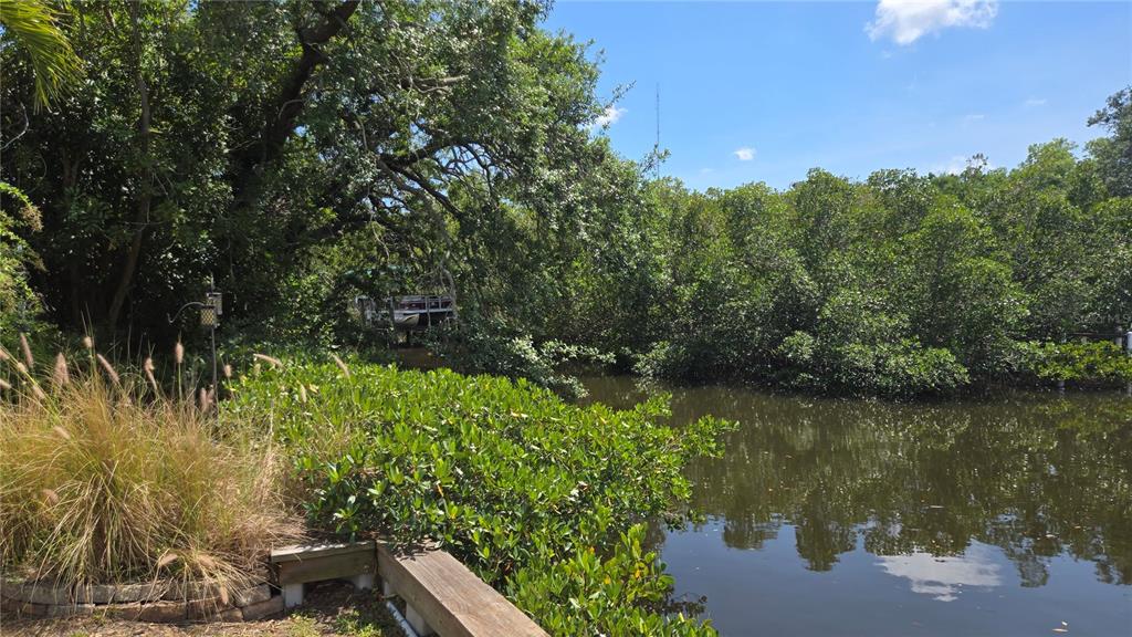 A view of a calm waterway bordered by dense trees and a wooden bulkhead — 3333 26TH AVENUE E UNIT 1291, BRADENTON, FL