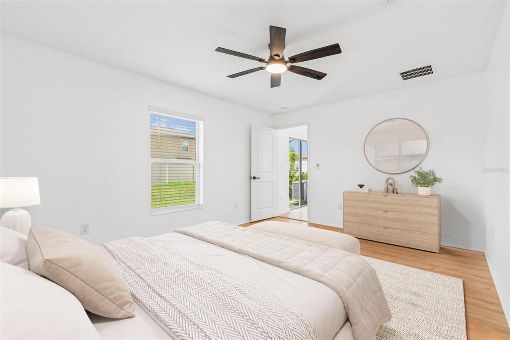 A bedroom features white walls, light wood flooring, a ceiling fan, and a wooden dresser — 7227 SALT RIVER, SUN CITY CENTER, FL