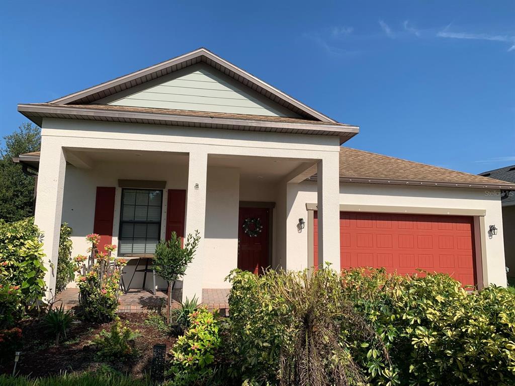 A one-story house with a red garage door, red shutters, and a covered front porch — 4063 WELLING TERRACE, LAND O LAKES, FL