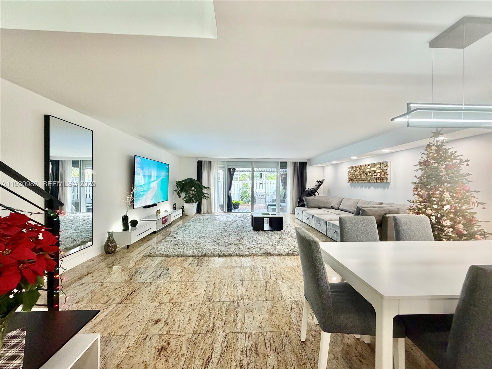 A spacious living and dining area features marble floors, a large sectional, and a Christmas tree — 934 NE 27th Ave, Hallandale Beach FL 33009, HALLANDALE BEACH, FL