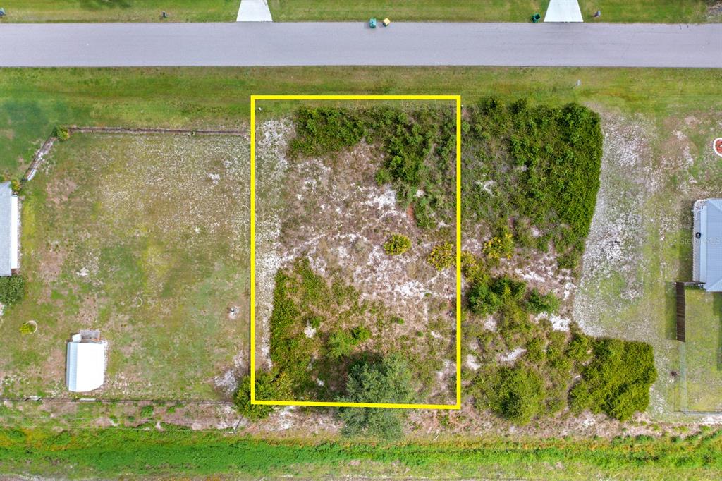 An aerial view shows a rectangular vacant lot outlined in yellow between two residential properties — 29331 LILLIS STREET, PUNTA GORDA, FL