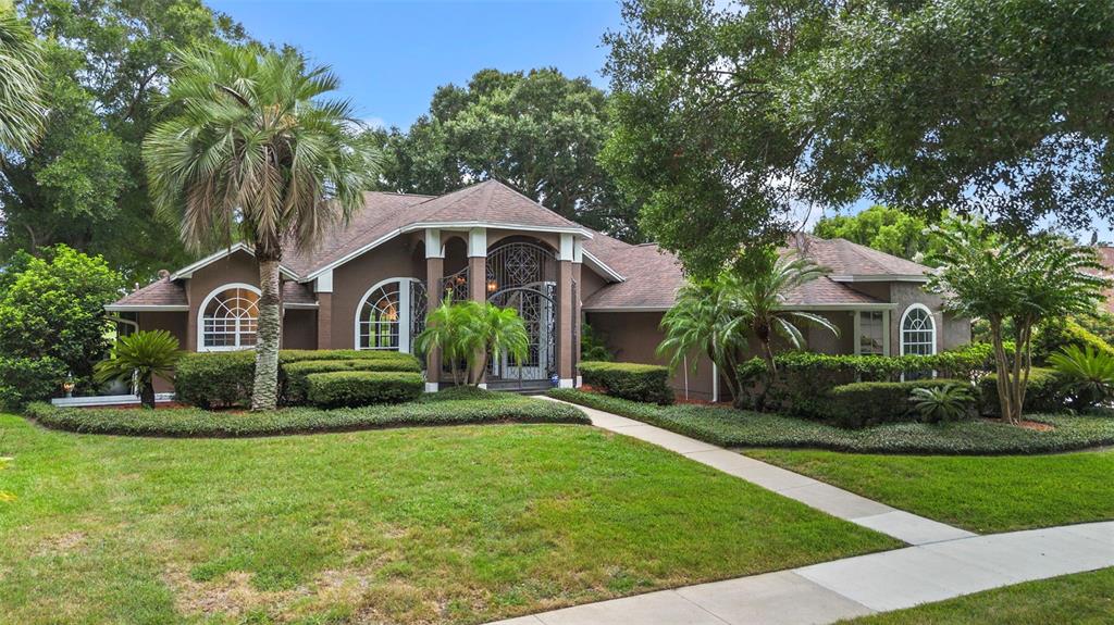 A brown single-story house with a decorative metal entryway and a manicured front lawn — 6631 CRENSHAW DRIVE, ORLANDO, FL