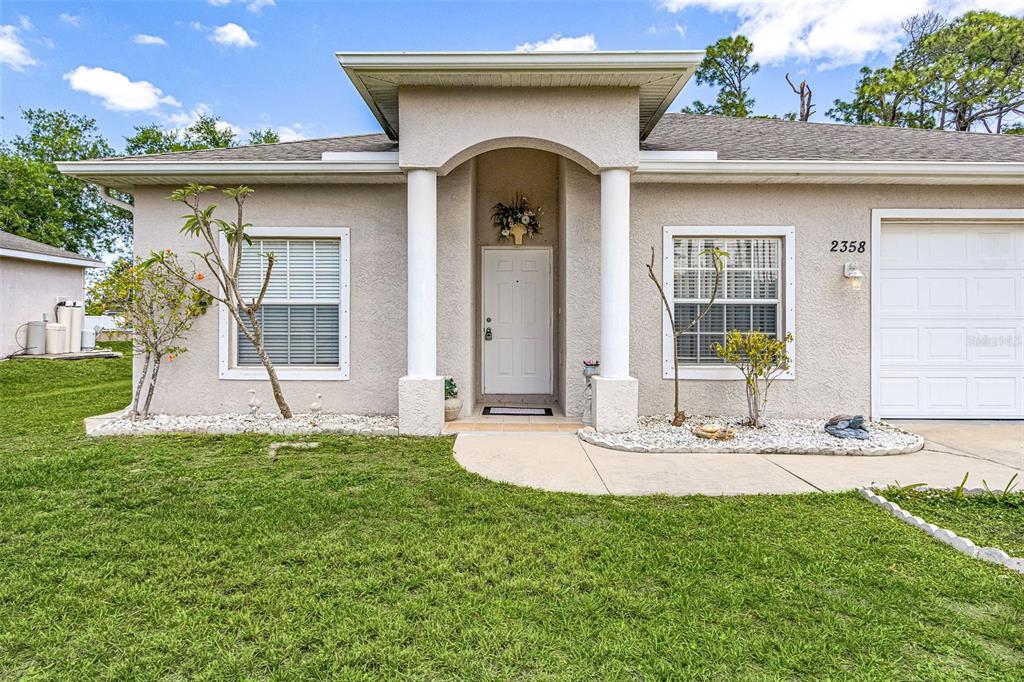 A single-story house with a white front door, two columns, and a garage — 2358 PILGER AVENUE, NORTH PORT, FL