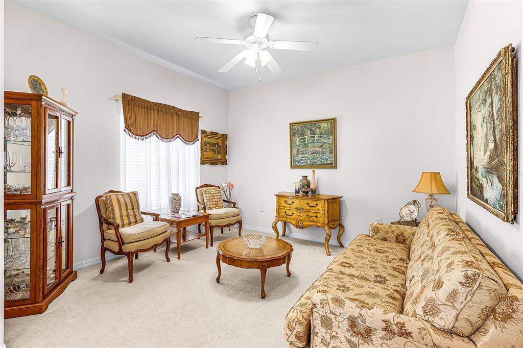 A formal living room features a patterned sofa, two armchairs, a coffee table, and cabinetry — 2358 PILGER AVENUE, NORTH PORT, FL