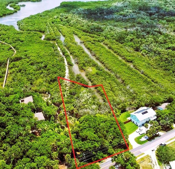An aerial view shows a rectangular plot of land outlined in red near mangroves — 4168 SAXON DRIVE, NEW SMYRNA BEACH, FL
