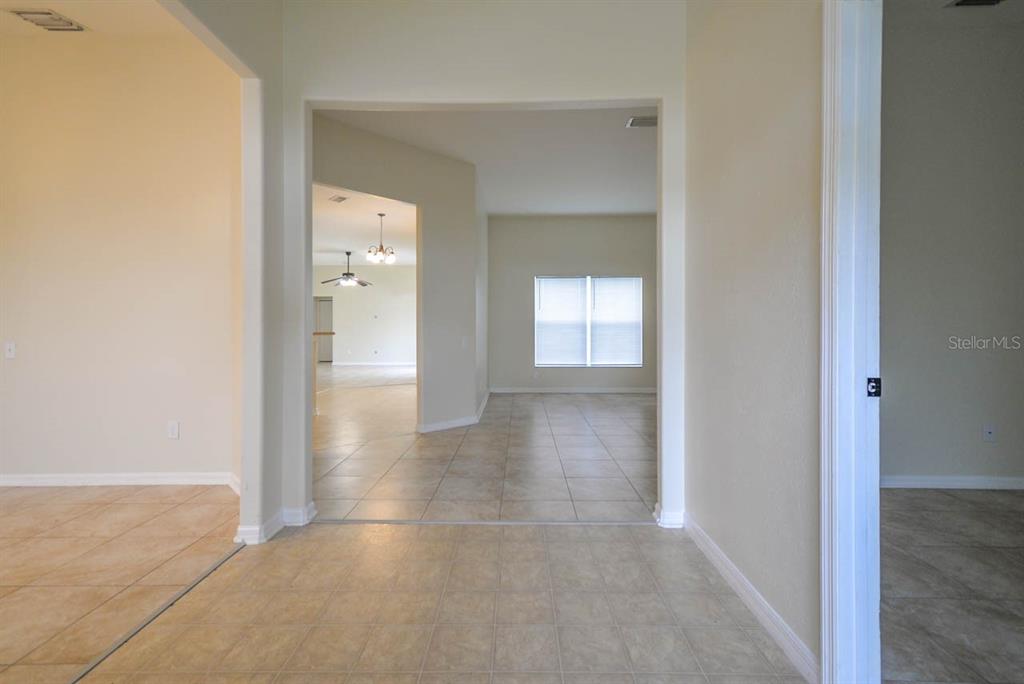 A tiled entryway leads into a living area with a window and an adjacent room — 1607 AVONDALE RIDGE DRIVE, PLANT CITY, FL