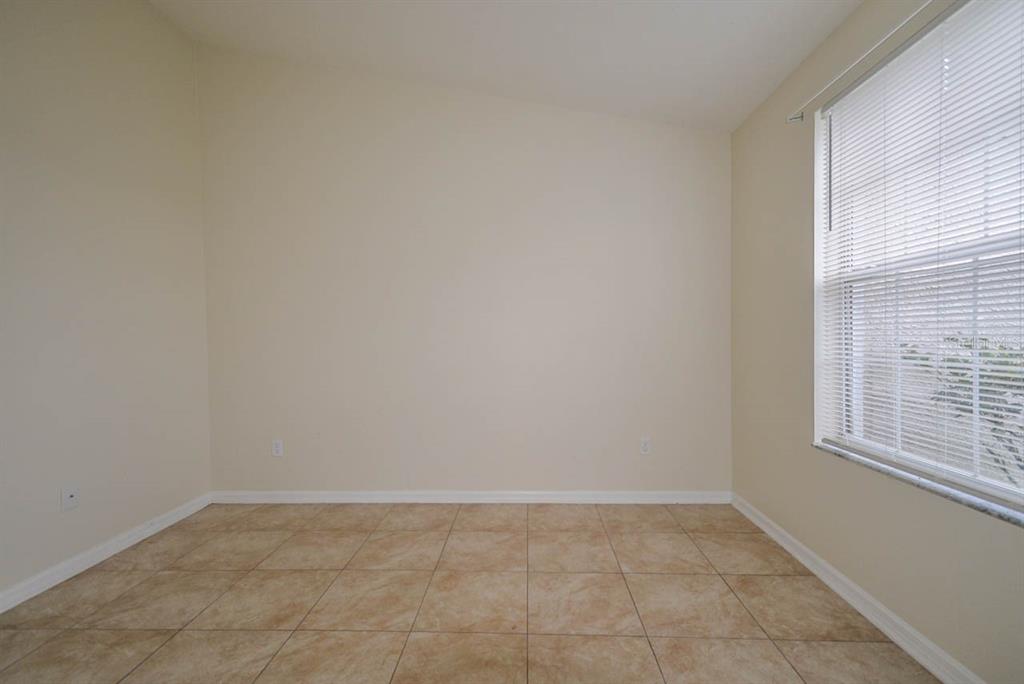 An empty room with beige walls, tile flooring, and a window with white blinds — 1607 AVONDALE RIDGE DRIVE, PLANT CITY, FL