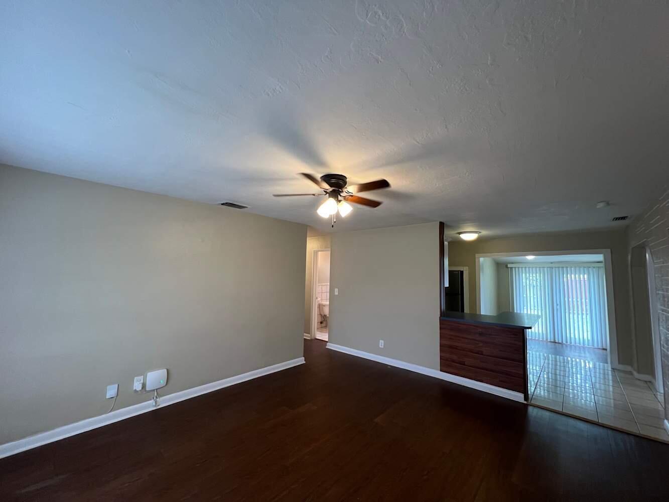 A living room with dark wood floors, beige walls, and a ceiling fan — DAVIE, FL