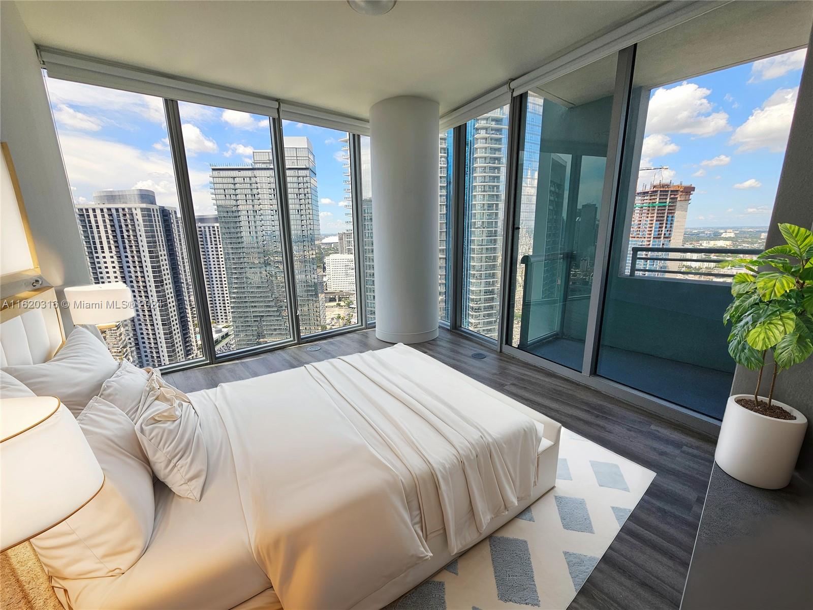 A modern bedroom features floor-to-ceiling windows with city views and a white platform bed — 888 Biscayne Blvd # 2701, Miami FL 33132, MIAMI, FL