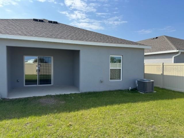 The exterior of a gray house features a covered patio, sliding glass doors, and an AC unit — 3649 YARIAN DRIVE, HAINES CITY, FL