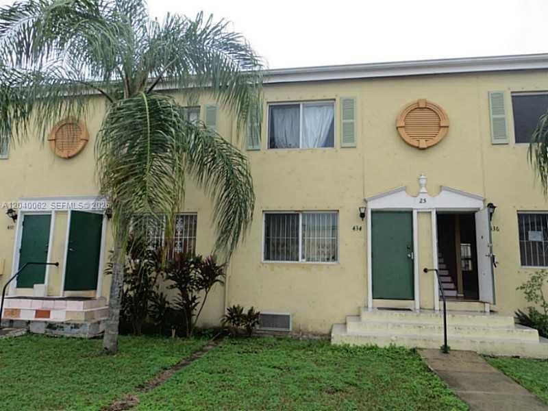 A two-story yellow apartment building with green doors, a palm tree, and a grassy lawn — 436 NW 84th Ter # 436, Miami FL 33150, MIAMI, FL