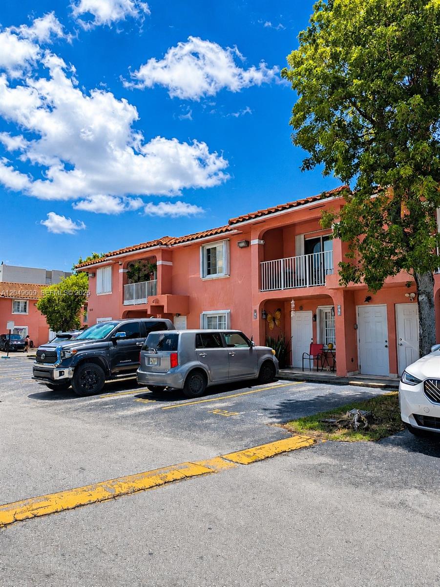 A two-story peach-colored apartment building with parked cars in the foreground — 5800 W 18th Ln, Hialeah FL 33012, HIALEAH, FL