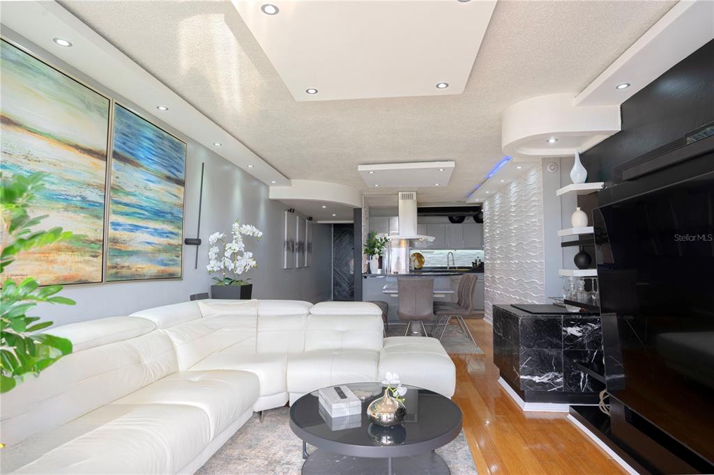 A modern living room features a white sectional sofa, a black coffee table, and hardwood floors — 1 CLUB COSTA MARINA UNIT 8-G, CAROLINA, PR