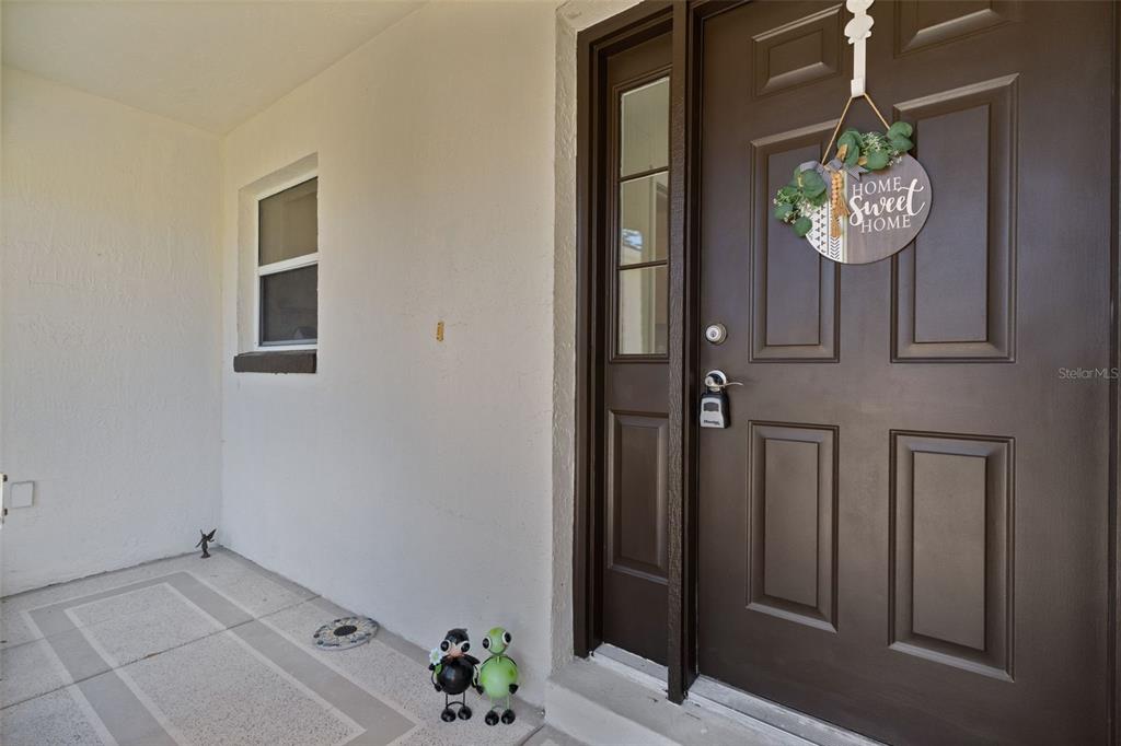 The exterior of a single-story house features a garage, a covered patio, and a lawn — 1012 DIEGO COURT, LADY LAKE, FL