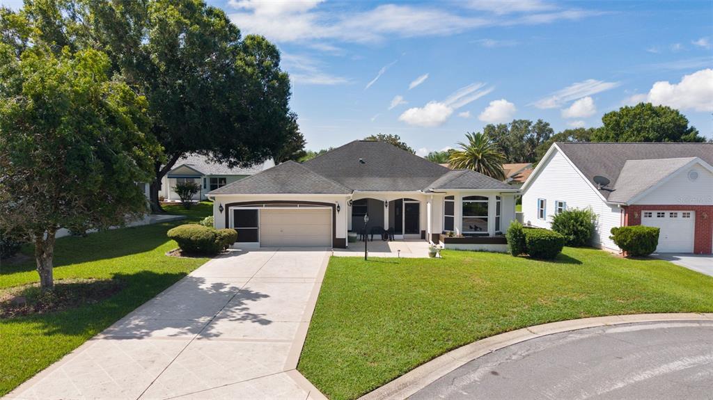A single-story suburban house with a two-car garage, a paved driveway, and a grassy lawn — 1012 DIEGO COURT, LADY LAKE, FL