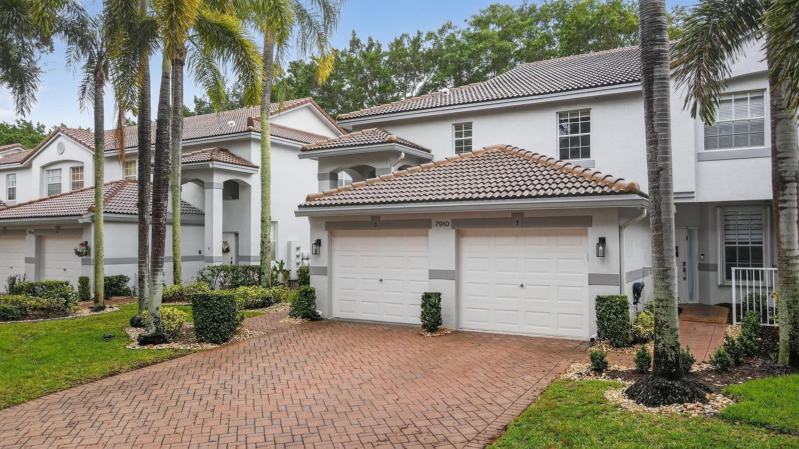 A two-story residential building features a brick driveway, two garage doors, and palm trees — 7910 Laina Lane # 3, Boynton Beach FL 33437, BOYNTON BEACH, FL