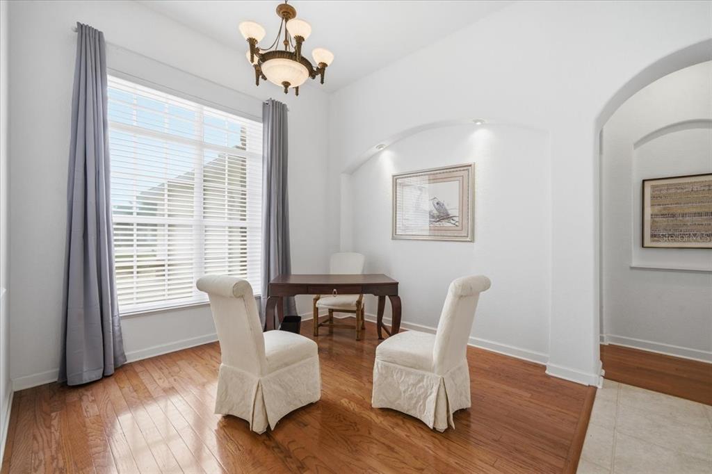 A dining room with hardwood floors, a wooden table, three chairs, and a chandelier — 5021 CHAMPIONSHIP CUP LANE, SPRING HILL, FL