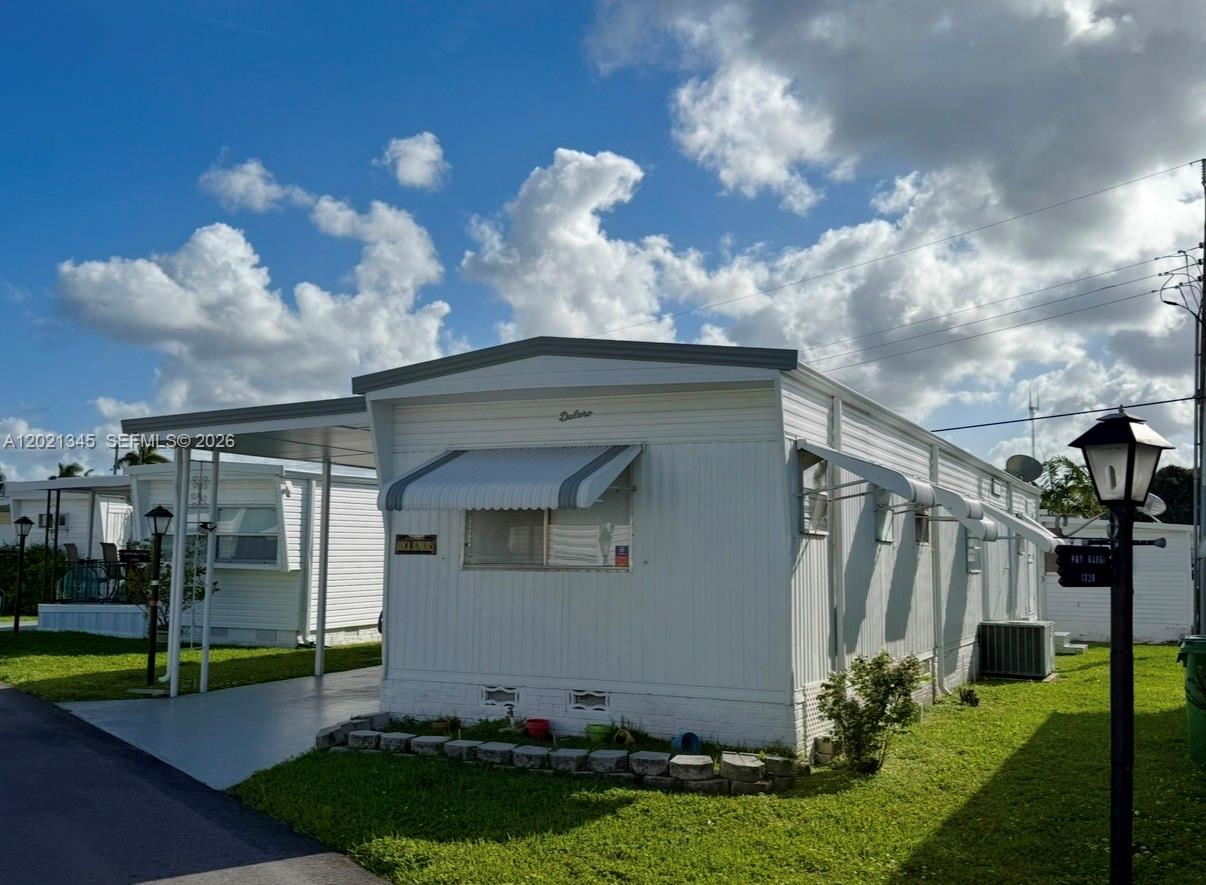 A white mobile home with a carport and an awning over the front window — 1332 S 33 AVE, Hollywood FL 33021, HOLLYWOOD, FL
