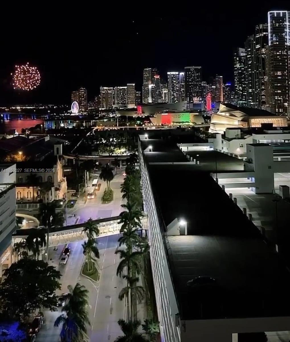 An elevated night view of a city skyline featuring a fireworks display and street traffic — 1750 N Bayshore Dr # 2010, Miami FL 33132, MIAMI, FL