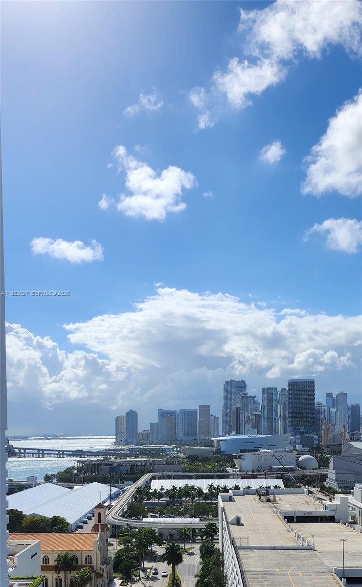 A high-angle view shows a city skyline, a bay, and a parking structure under a cloudy sky — 1750 N Bayshore Dr # 2010, Miami FL 33132, MIAMI, FL