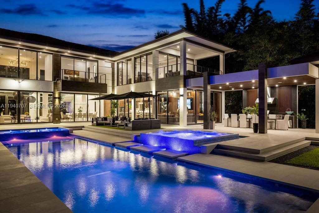 A modern two-story house features a large swimming pool, a hot tub, and outdoor seating — 6850 SW 73rd Ct, Miami FL 33143, MIAMI, FL