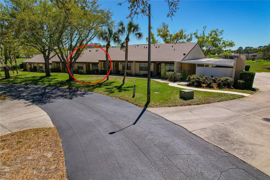 A view of the exterior of a single-story residential building with a red circle — 11241 DOLLAR LAKE DRIVE UNIT 4, PORT RICHEY, FL