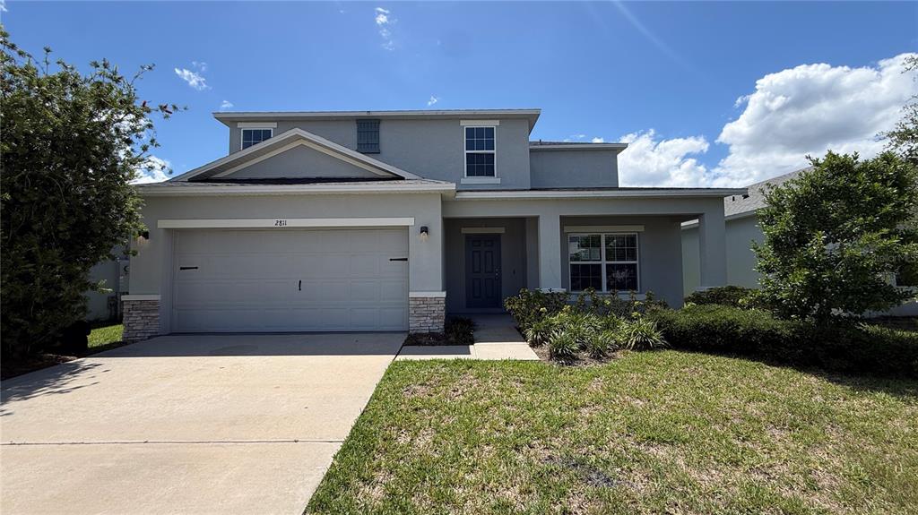 A two-story suburban house features a gray exterior, a two-car garage, and a front porch — 2811 PARKFIELD ROAD, ST CLOUD, FL