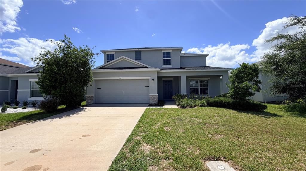 A two-story suburban house features a gray exterior, a two-car garage, and a front lawn — 2811 PARKFIELD ROAD, ST CLOUD, FL