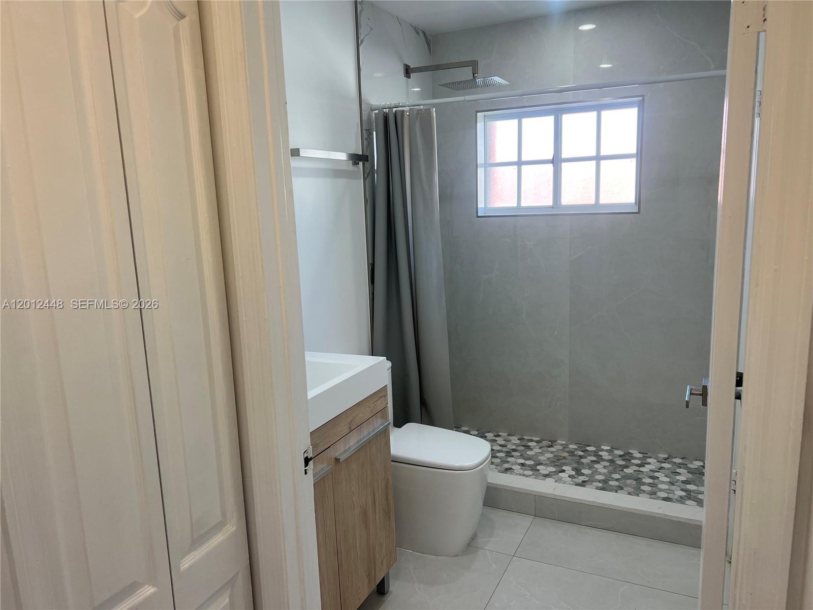 A straight staircase features light gray tiled steps and wooden handrails on both sides — 2425 W 76th St # 207, Hialeah FL 33016, HIALEAH, FL
