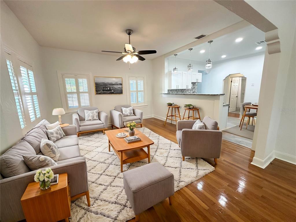 A living room with hardwood floors, a large area rug, and an open kitchen pass-through — 3025 W NORTH A STREET, TAMPA, FL