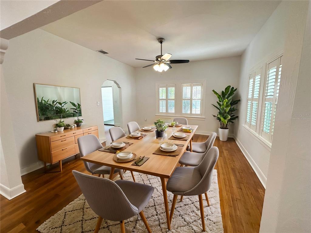 A dining room features a wooden table with six chairs, a sideboard, and hardwood floors — 3025 W NORTH A STREET, TAMPA, FL