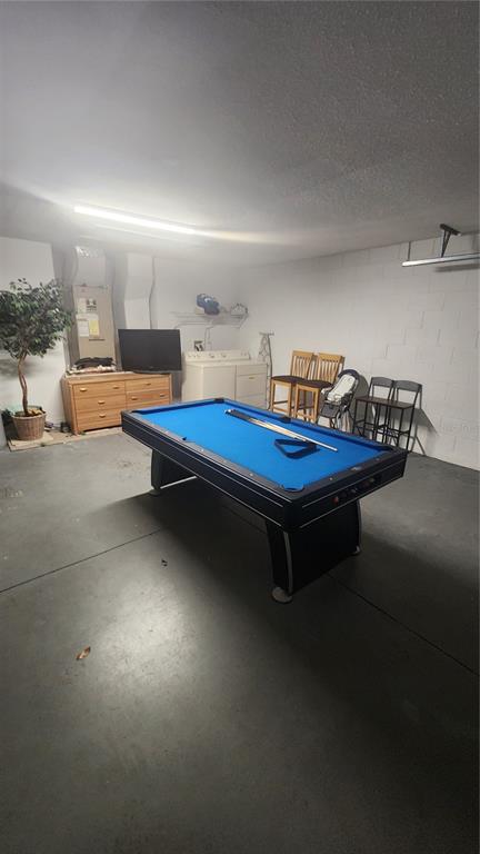 A garage converted into a game room featuring a blue pool table and laundry appliances — 2618 EMERALD ISLAND BOULEVARD, KISSIMMEE, FL