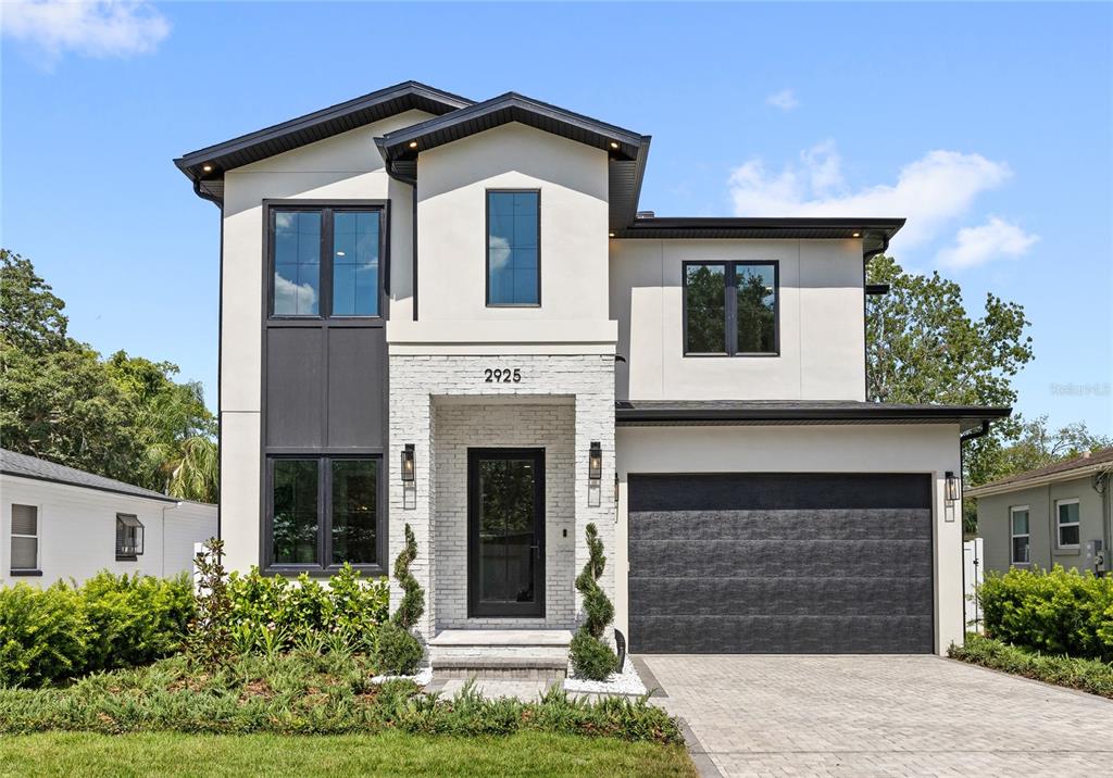A two-story modern house features white stucco, a brick entryway, and a black garage door — 2925 OBERLIN AVENUE, ORLANDO, FL