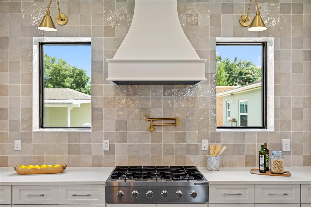 A kitchen features a stainless steel gas range, a white hood, and light-colored square tiles — 2925 OBERLIN AVENUE, ORLANDO, FL