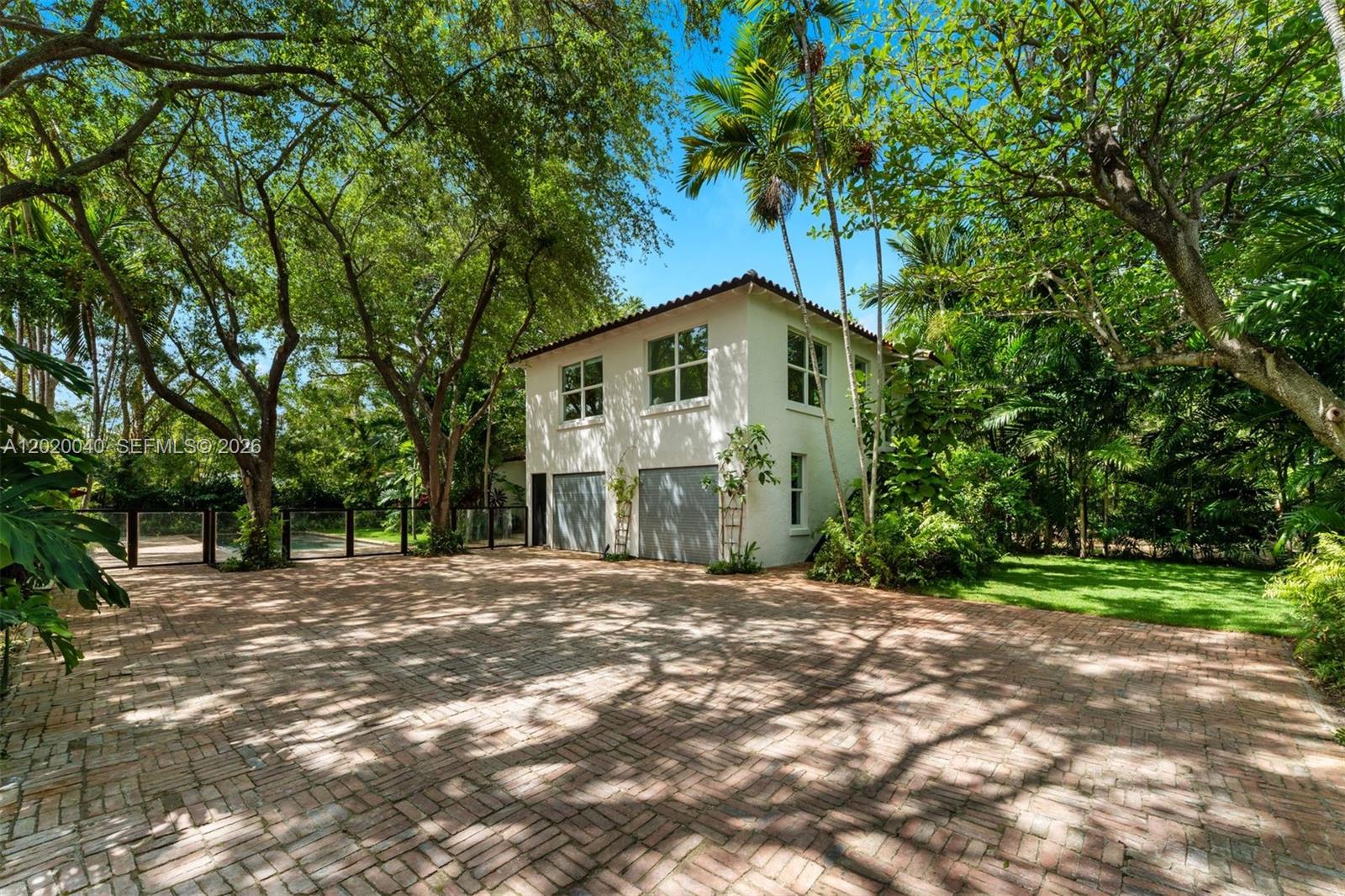 A two-story white building with a brick driveway and surrounding trees — 5812 Alton Rd, Miami Beach FL 33140, MIAMI BEACH, FL