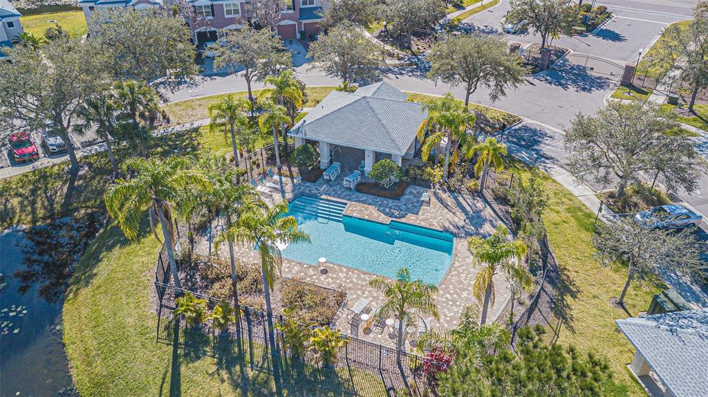 An aerial view shows a community swimming pool with a covered pavilion and palm trees — 26544 CASTLEVIEW WAY, WESLEY CHAPEL, FL