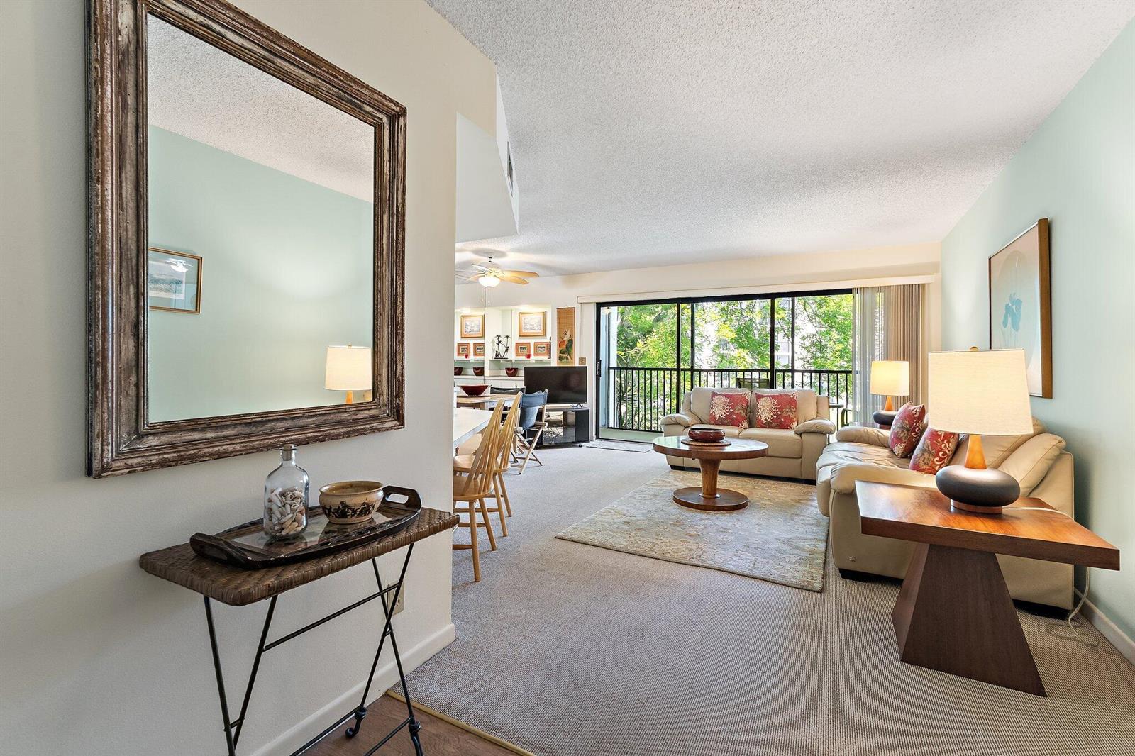 A living room with beige sofas, a round coffee table, and a balcony view — 1605 S Us Highway 1 # B205, Jupiter FL 33477, JUPITER, FL