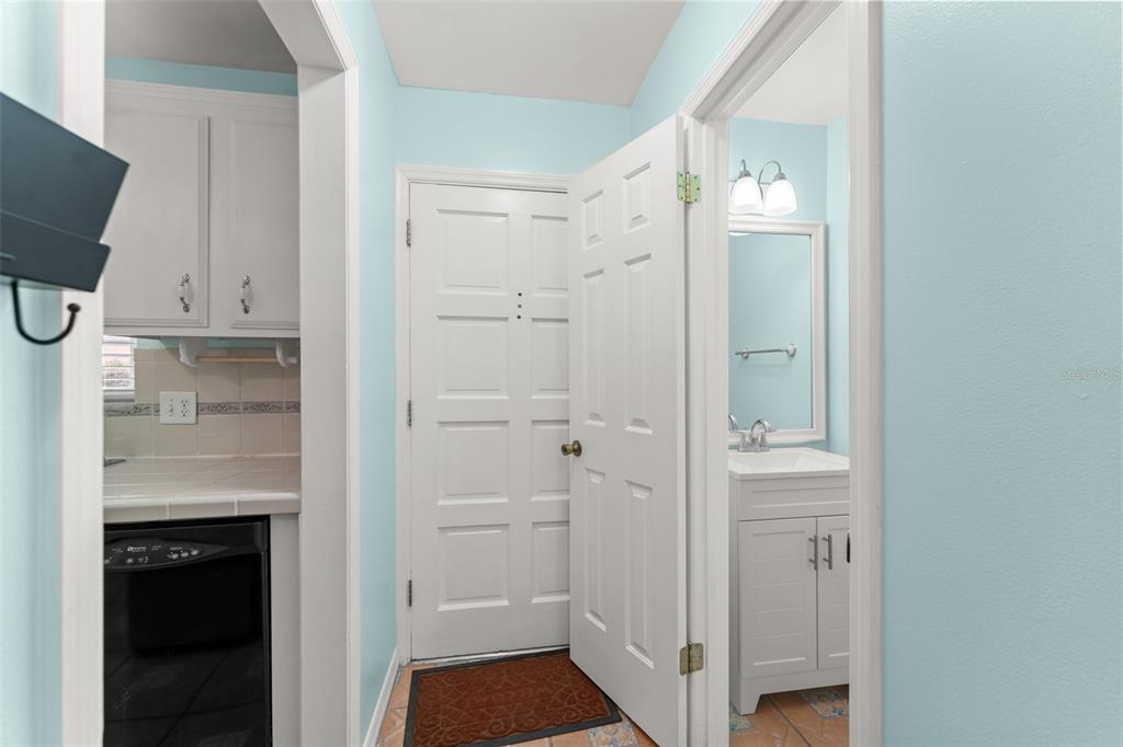 A hallway connects a kitchen area with a white cabinet vanity and a bathroom — 1220 VILLA LANE UNIT 135, APOPKA, FL