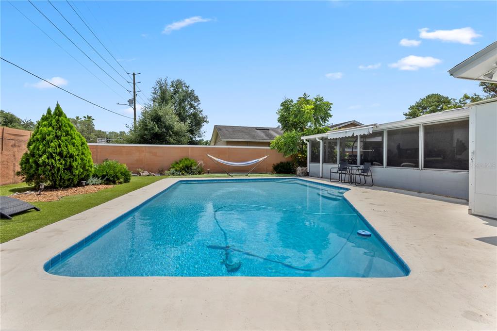 A backyard features a rectangular swimming pool, a hammock, and a screened-in patio area — 961 APPLE LANE, ALTAMONTE SPRINGS, FL