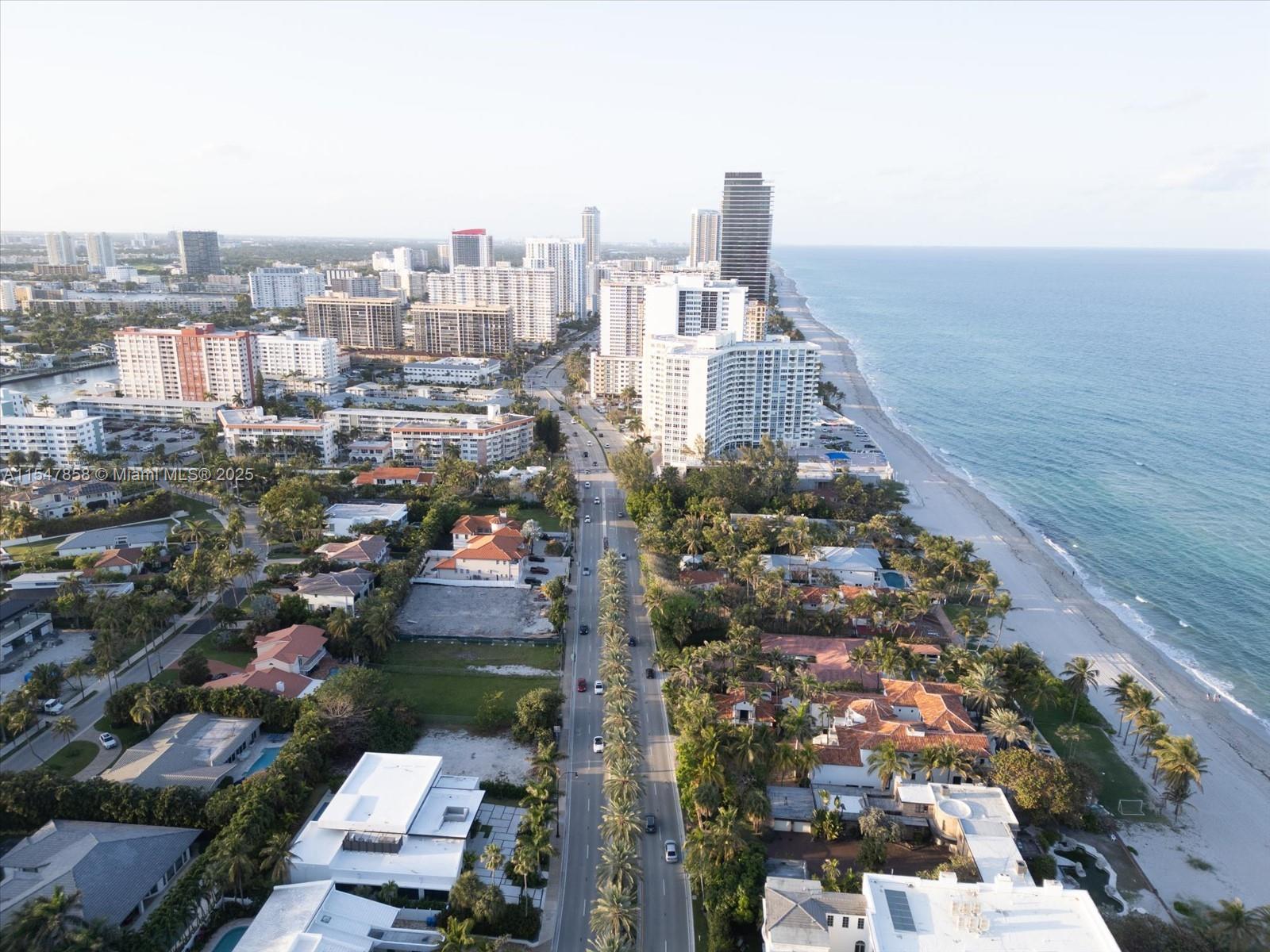 An aerial view shows a coastal city with a road running between houses and beachside buildings — 624 Ocean Blvd, Golden Beach FL 33160, GOLDEN BEACH, FL