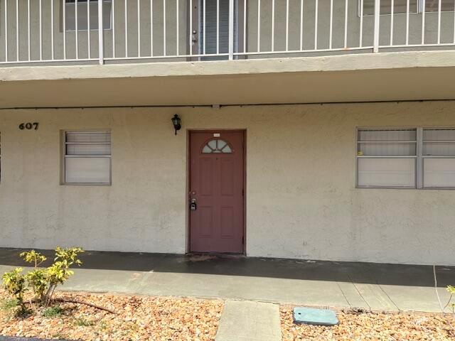 A ground-level apartment entrance features a brown door, two windows, and a concrete walkway — 607 S State Rd 7 # 1g, Margate FL 33068, MARGATE, FL
