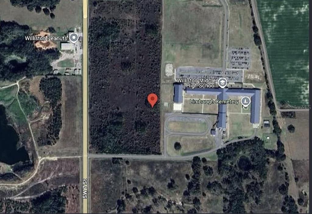 This is a satellite map view showing a wooded lot next to a school — 0 SW 19TH AVENUE, WILLISTON, FL