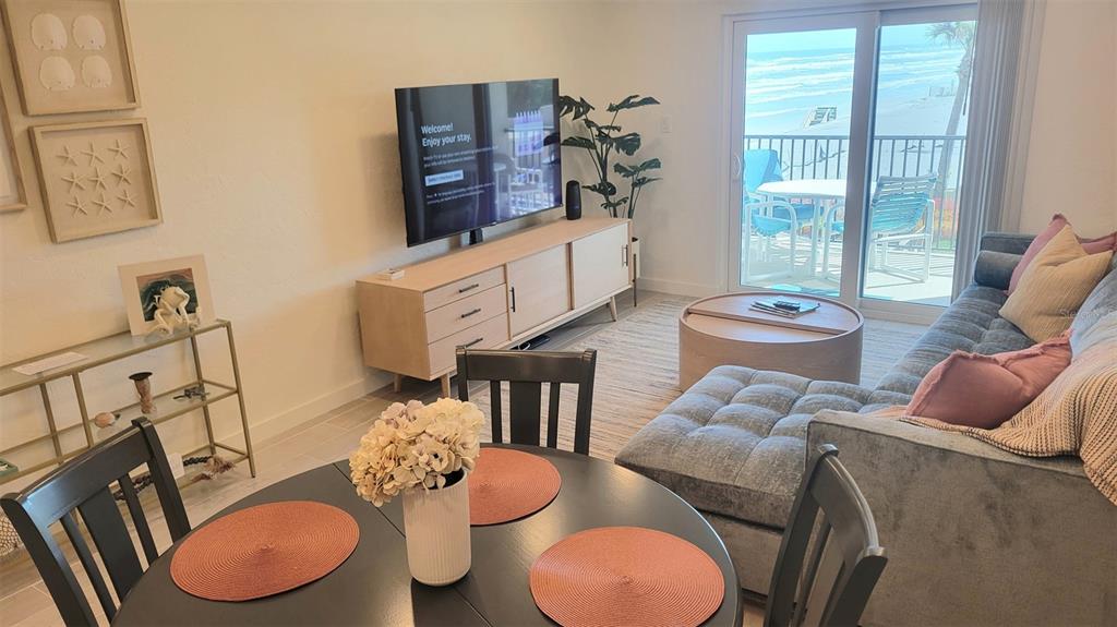A living room and dining area feature a balcony with an ocean view — 4301 S ATLANTIC AVENUE UNIT 2110, NEW SMYRNA BEACH, FL