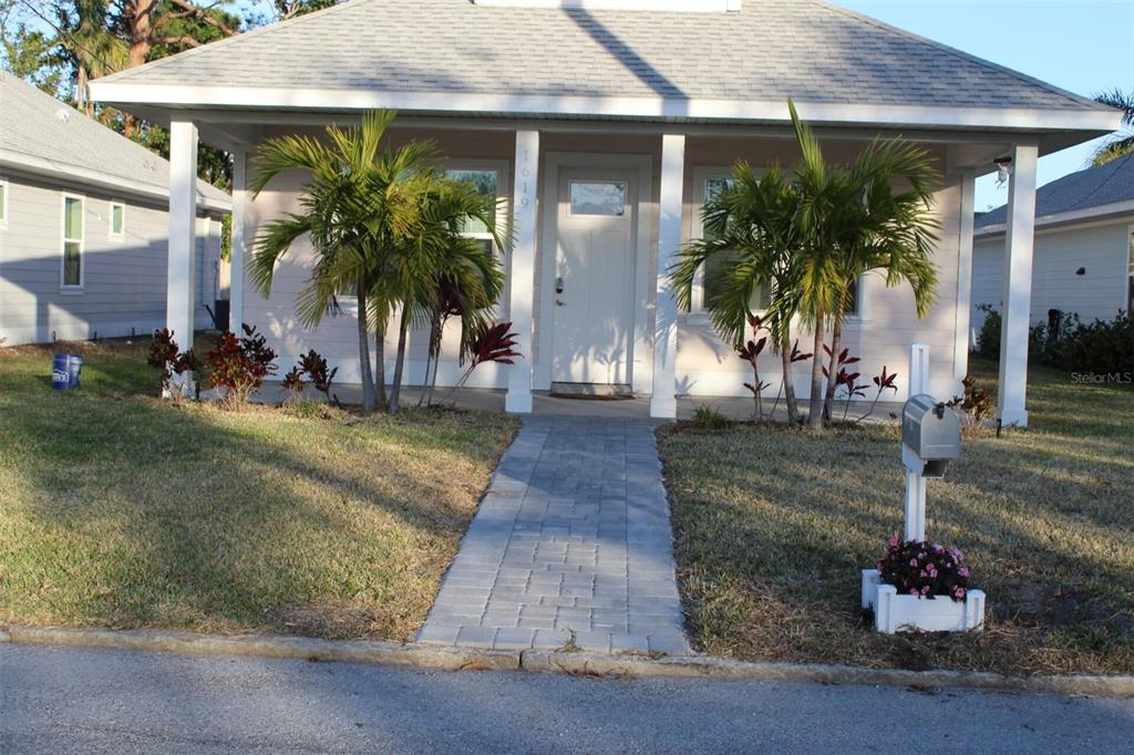 A single-story house with a covered front porch, palm trees, and a paved walkway — 1619 17TH STREET W, BRADENTON, FL