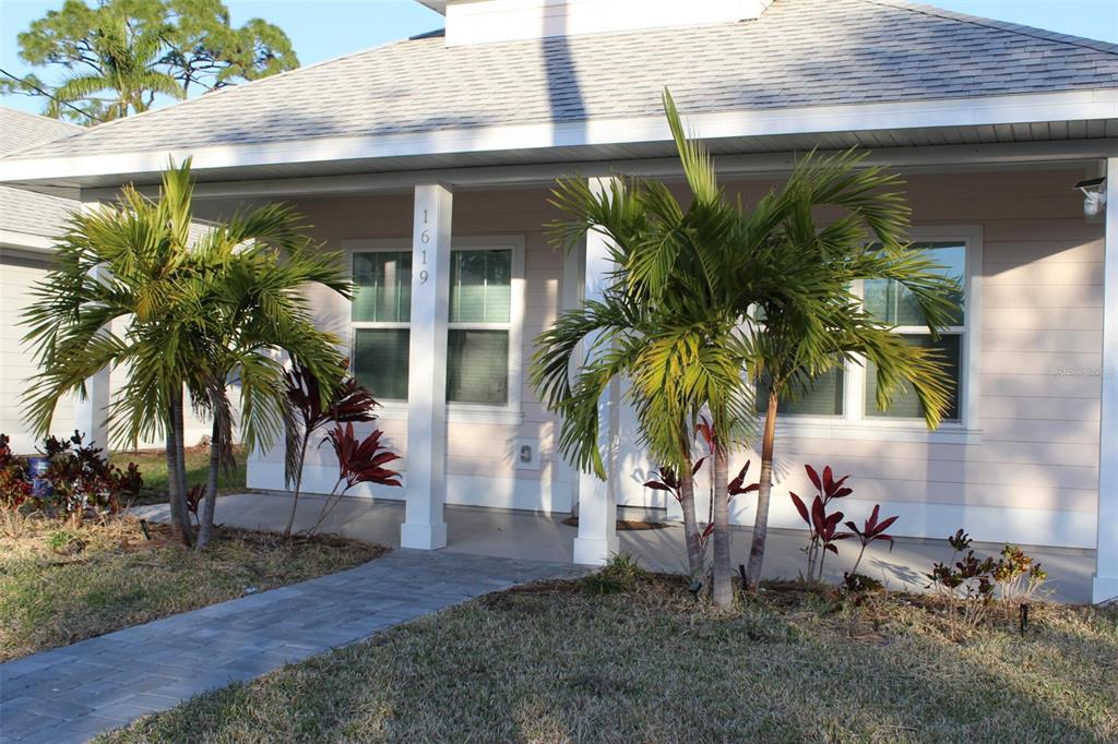 A light-colored house exterior features a covered front porch, two palm trees, and a walkway — 1619 17TH STREET W, BRADENTON, FL