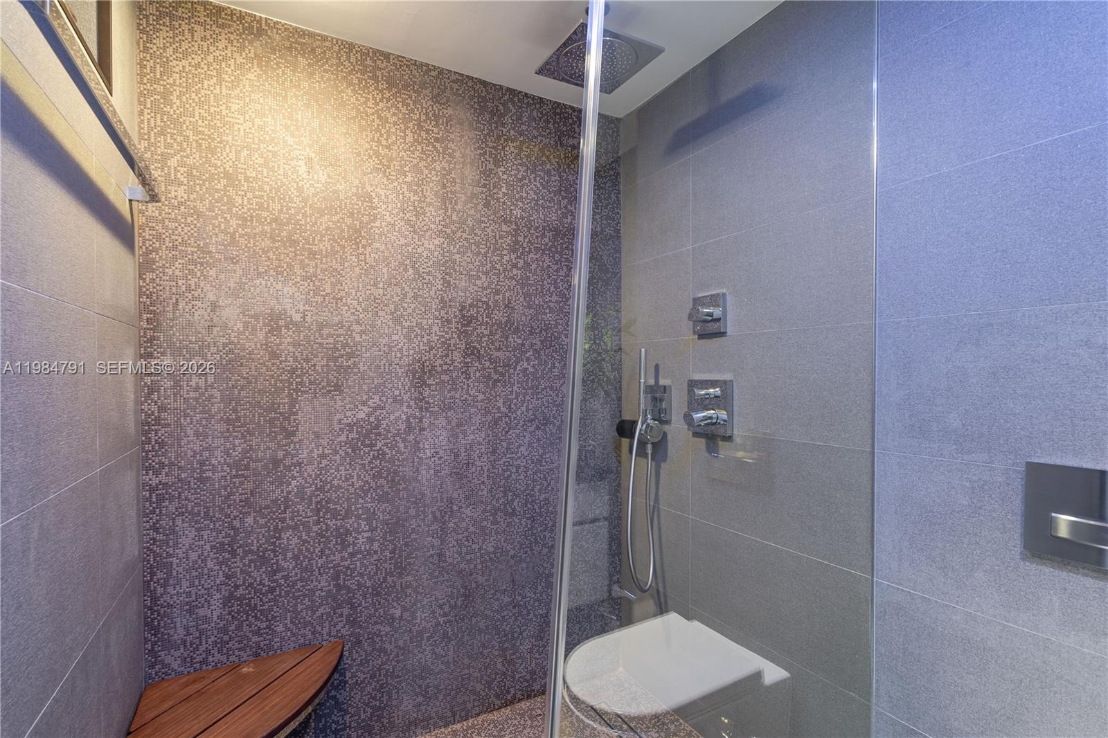 A modern shower features a mosaic tile accent wall, a teak bench, and glass enclosure — 2627 S Bayshore Dr # 1408, Miami FL 33133, MIAMI, FL