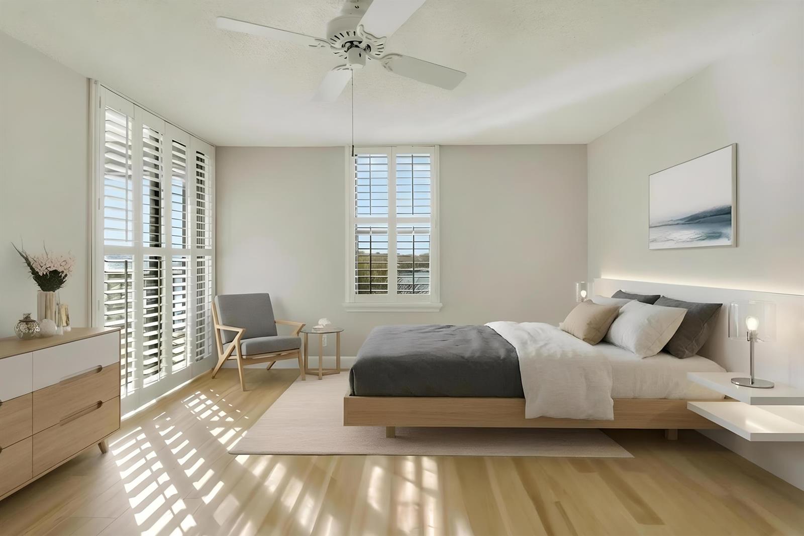 A modern bedroom features a platform bed, light wood floors, plantation shutters, and a ceiling fan — 1748 Jupiter Cove Drive # 417, Jupiter FL 33469, JUPITER, FL